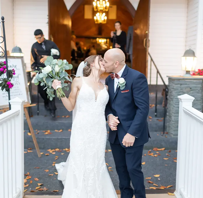 Bride and groom kissing in front of chapel