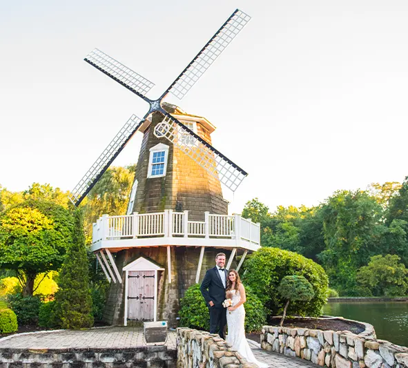 Bride and groom standing in front of the windmill at Aqua Turf Club