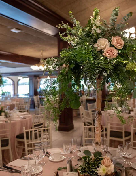 Tall floral arrangement on a table in the Wagon Room