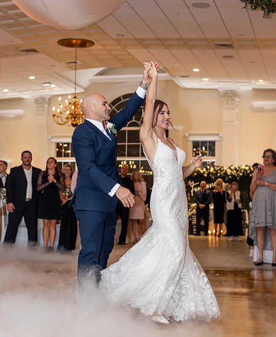 Groom twirling bride on dance floor