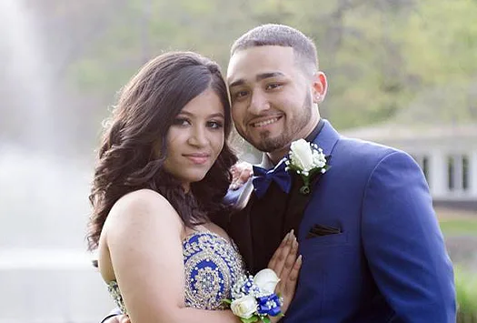 Young man and woman pose outdoors at their prom