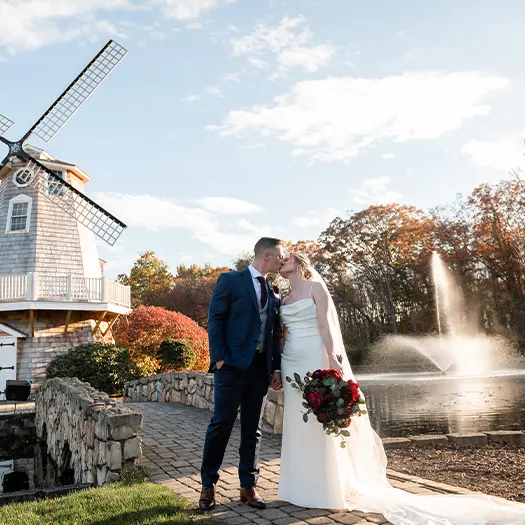 Bride and groom kiss in front of the windmill